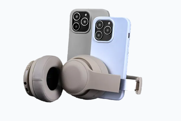 A pair of over-ear wireless headphones in a warm gray-beige color, shown with two smartphones (one gray, one light blue) inserted into a phone mount on the headband, against a solid white background.